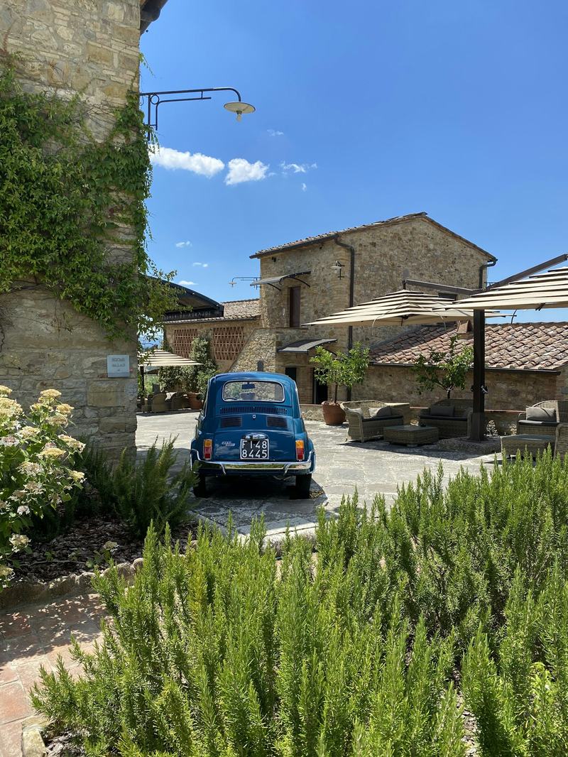 Casale toscano in pietra con rosmarino e auto d'epoca